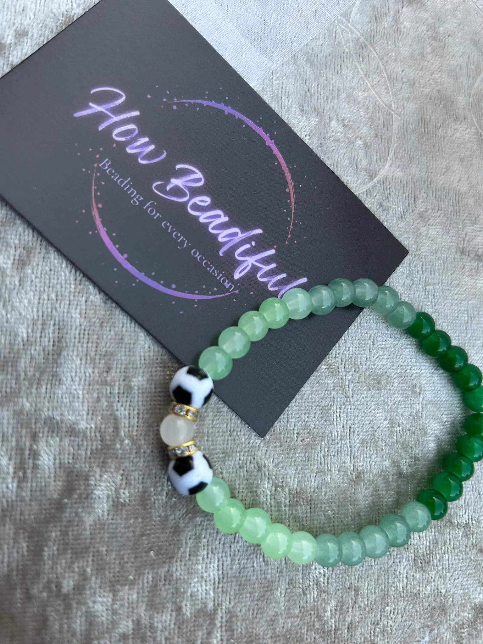 Hands threading beads onto a bracelet